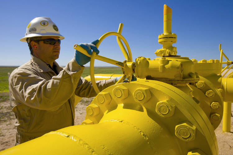Worker maintaining a large yellow pipe